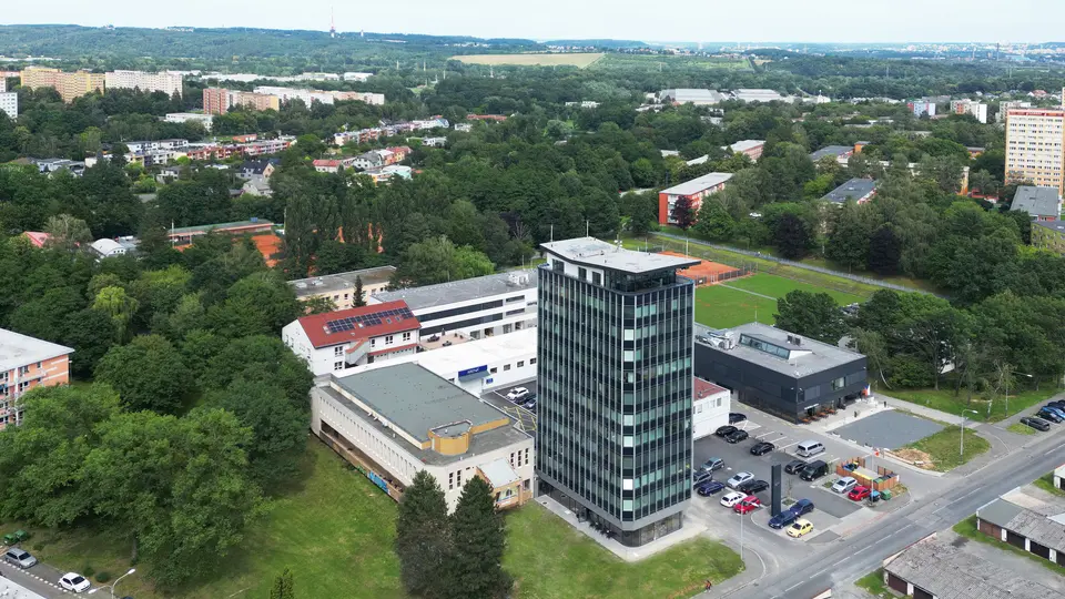 Letecký pohled na administrativní budovu Černá perla v Ostravě po rekonstrukci, s prosklenou fasádou a okolní městskou zelení.