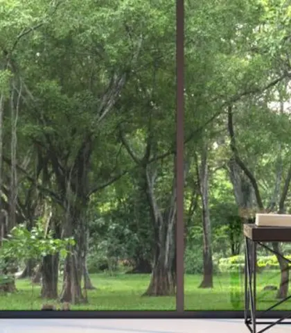 Moderní interiér s křeslem u velkých prosklených oken s výhledem do zeleného lesa.