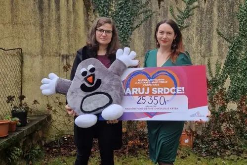 Dvě ženy drží symbolický šek na částku 25 350 Kč od skupiny Saint-Gobain pro Nadační fond dětské onkologie KRTEK a velkého plyšového krtka